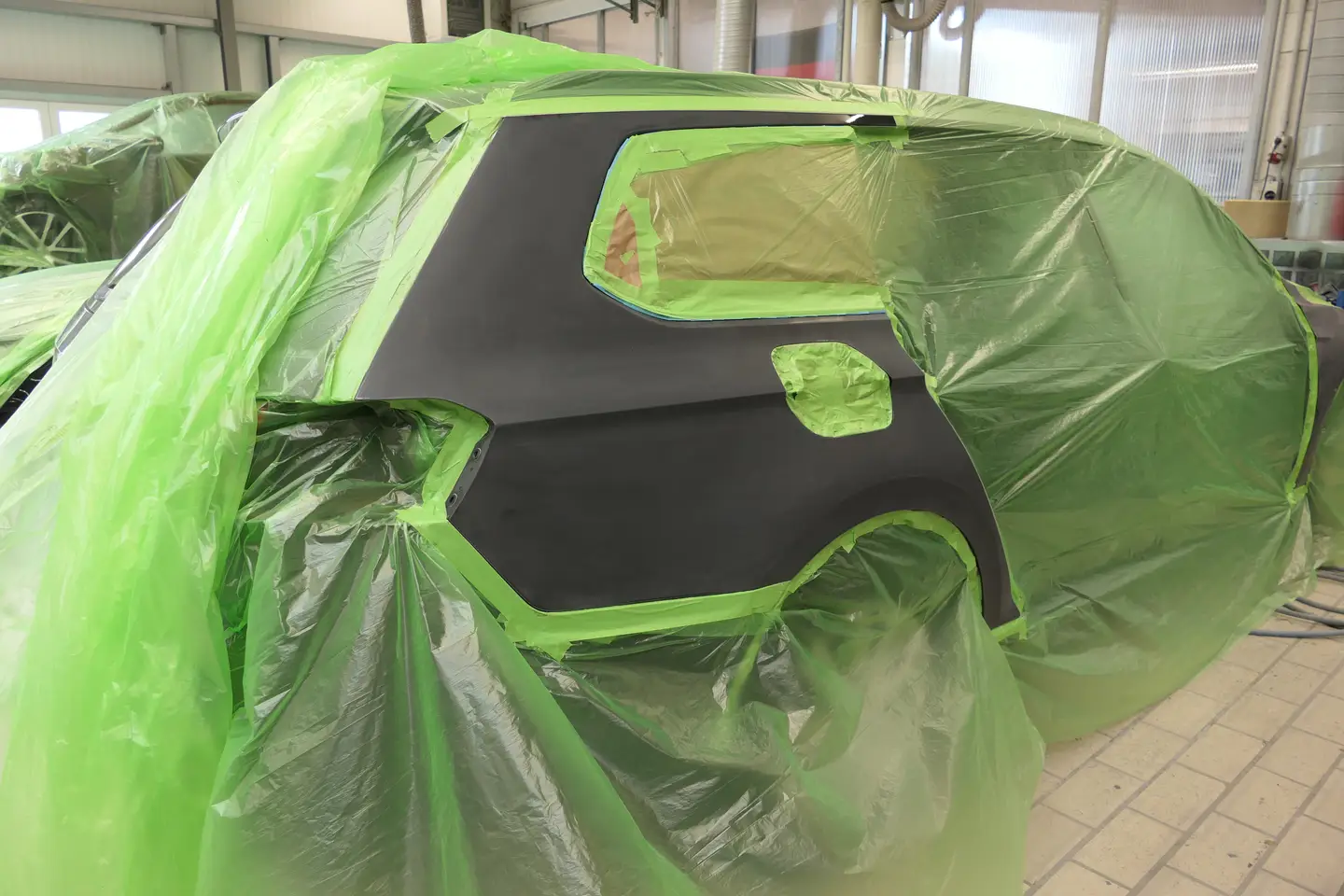 Impressionen Mit giftgrüner Folie abgeklebtes Kundenfahrzeug zur Lackierung des hinteren rechten Seitenteils